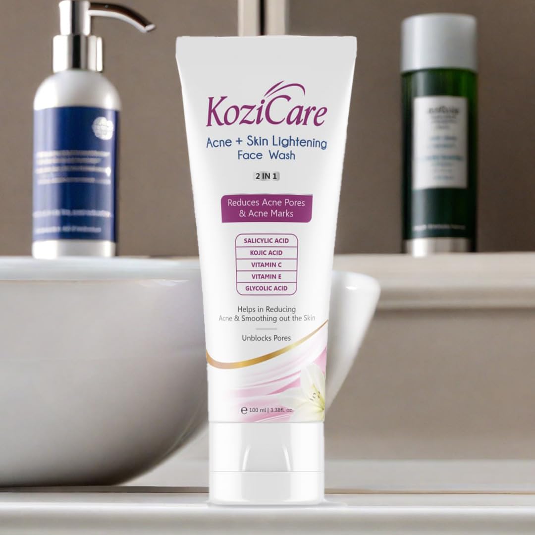 KoziCare Acne + Skin Lightening Face Wash tube on a bathroom counter with other skincare products.