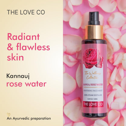 Kannauj rose water bottle with pink label on a background of pink rose petals, featuring 'The Love Co' brand.