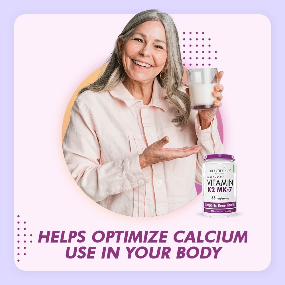 Woman holding a glass of milk with a bottle of Vitamin K2 MK-7 supplement on a light purple background.