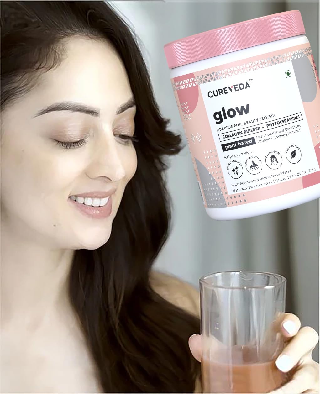 Woman holding a glass of a protein shake next to a container labeled 'Cureveda Glow'.