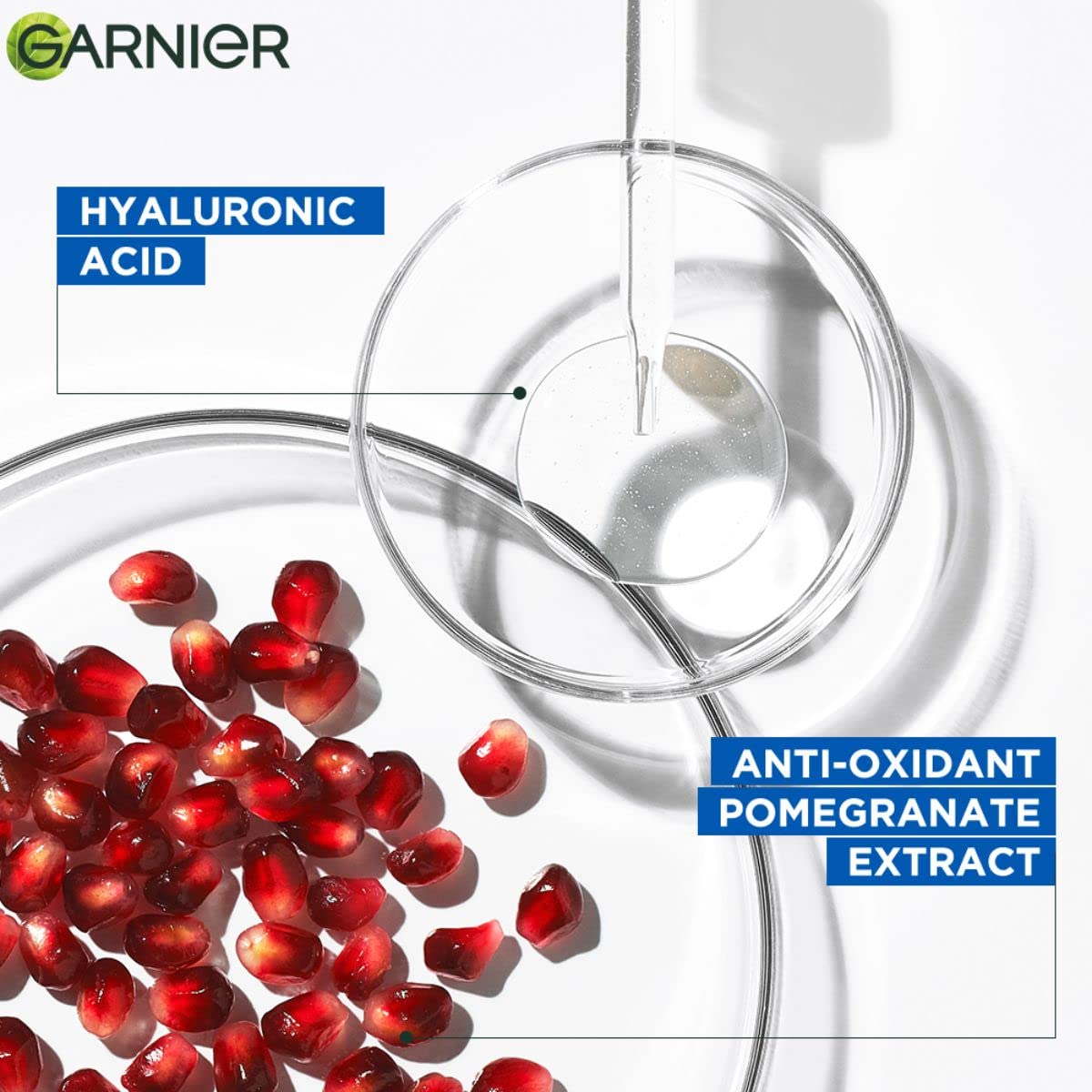 Garnier skincare product with pomegranate seeds and a petri dish on a white background