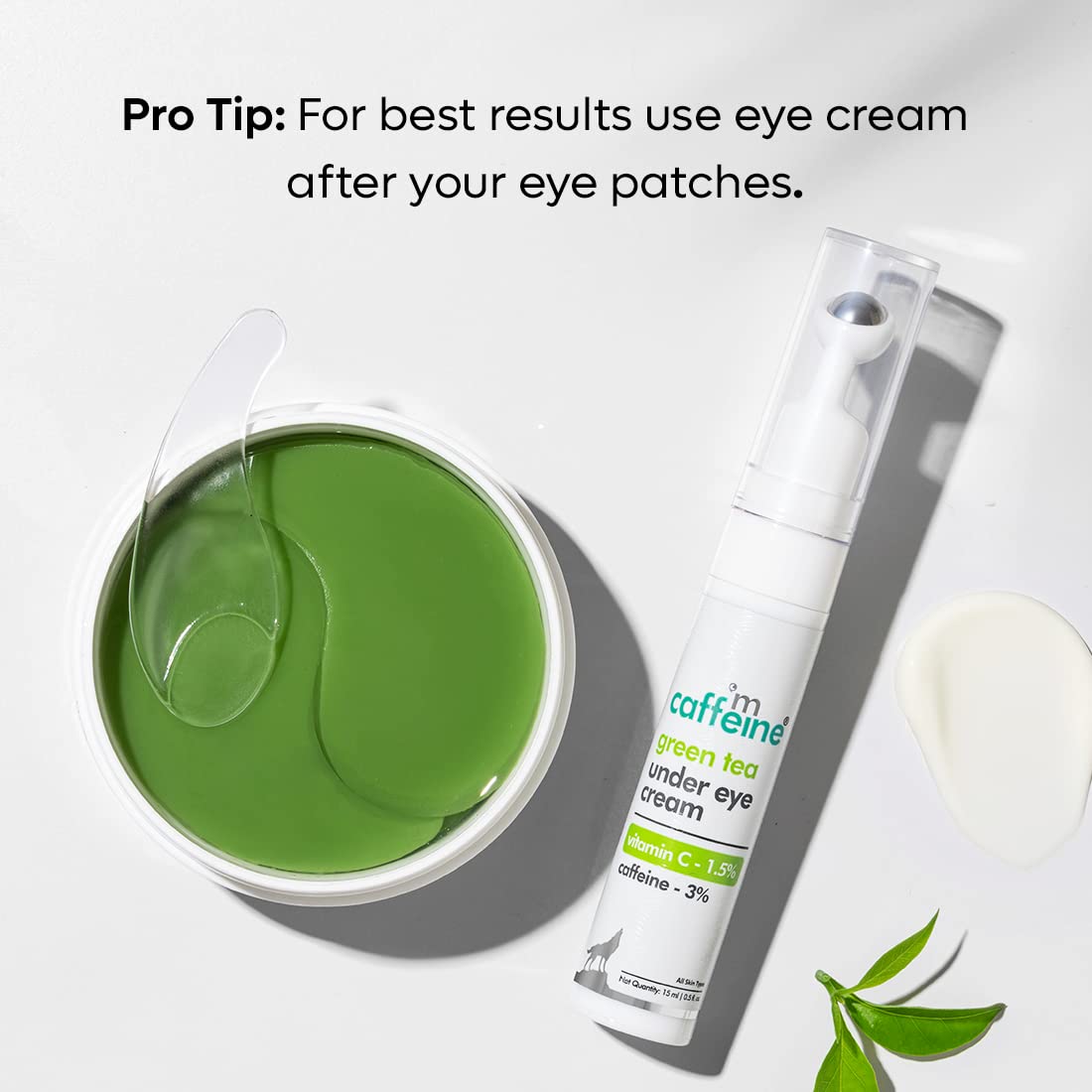 Green tea eye patches in a container with a bottle of eye cream on a white background.