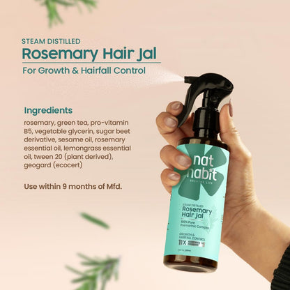 Hand holding a bottle of 'nat habit' Rosemary Hair Jal with product details on a beige background