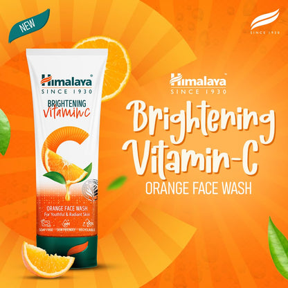 Himalaya Brightening Vitamin C Orange Face Wash packaging on an orange background with oranges and leaves.