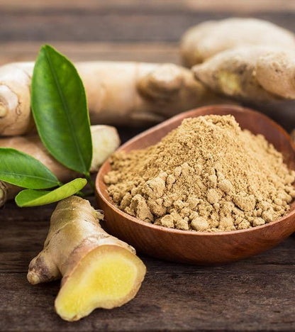 Ginger root and powder on a wooden surface