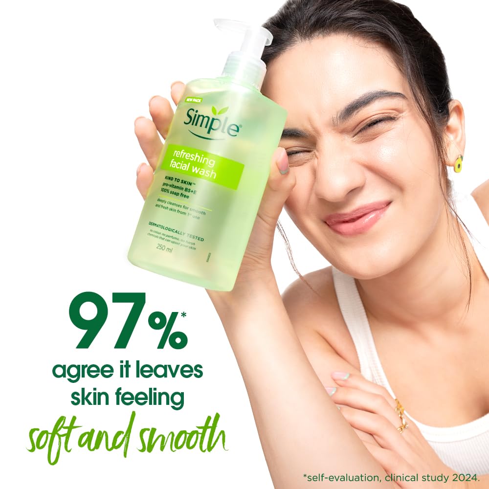 Woman holding a bottle of Simple refreshing facial wash with text about skin softness.