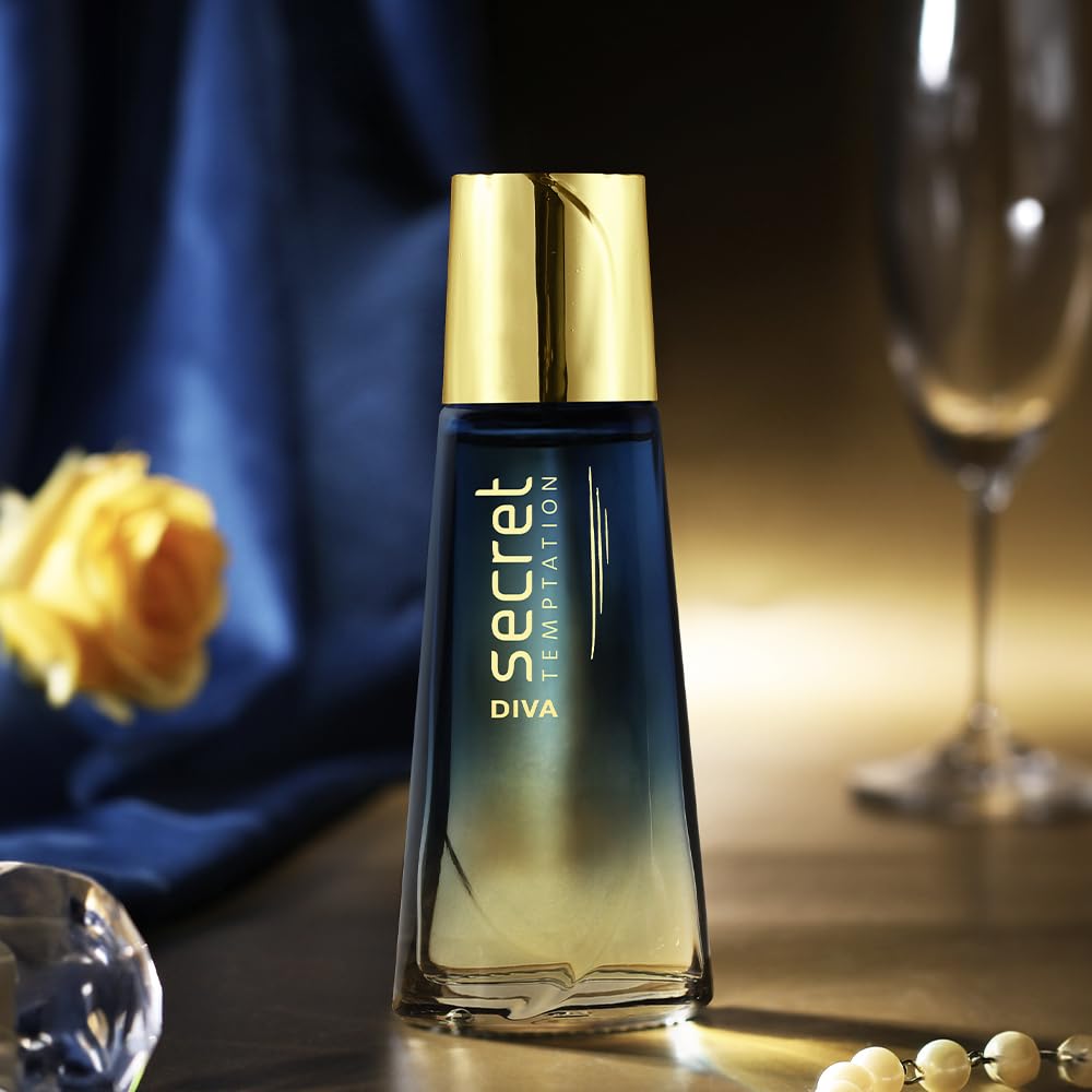 Perfume bottle labeled 'Secret Temptation Diva' with a yellow rose and glassware in the background
