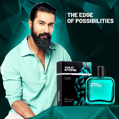 Man with a beard sitting next to Wild Stone Edge perfume bottle and packaging on a green background