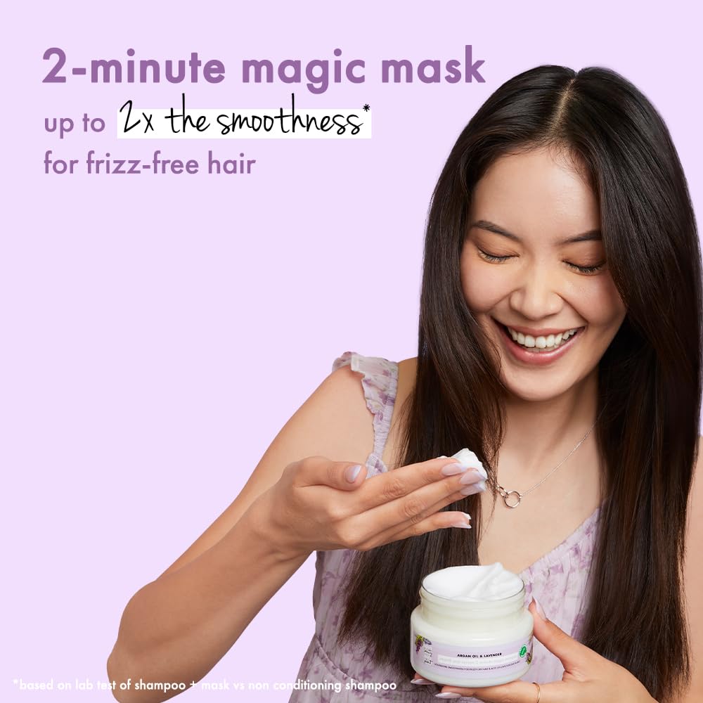 Woman applying a 2-minute magic mask to her hair with a purple background