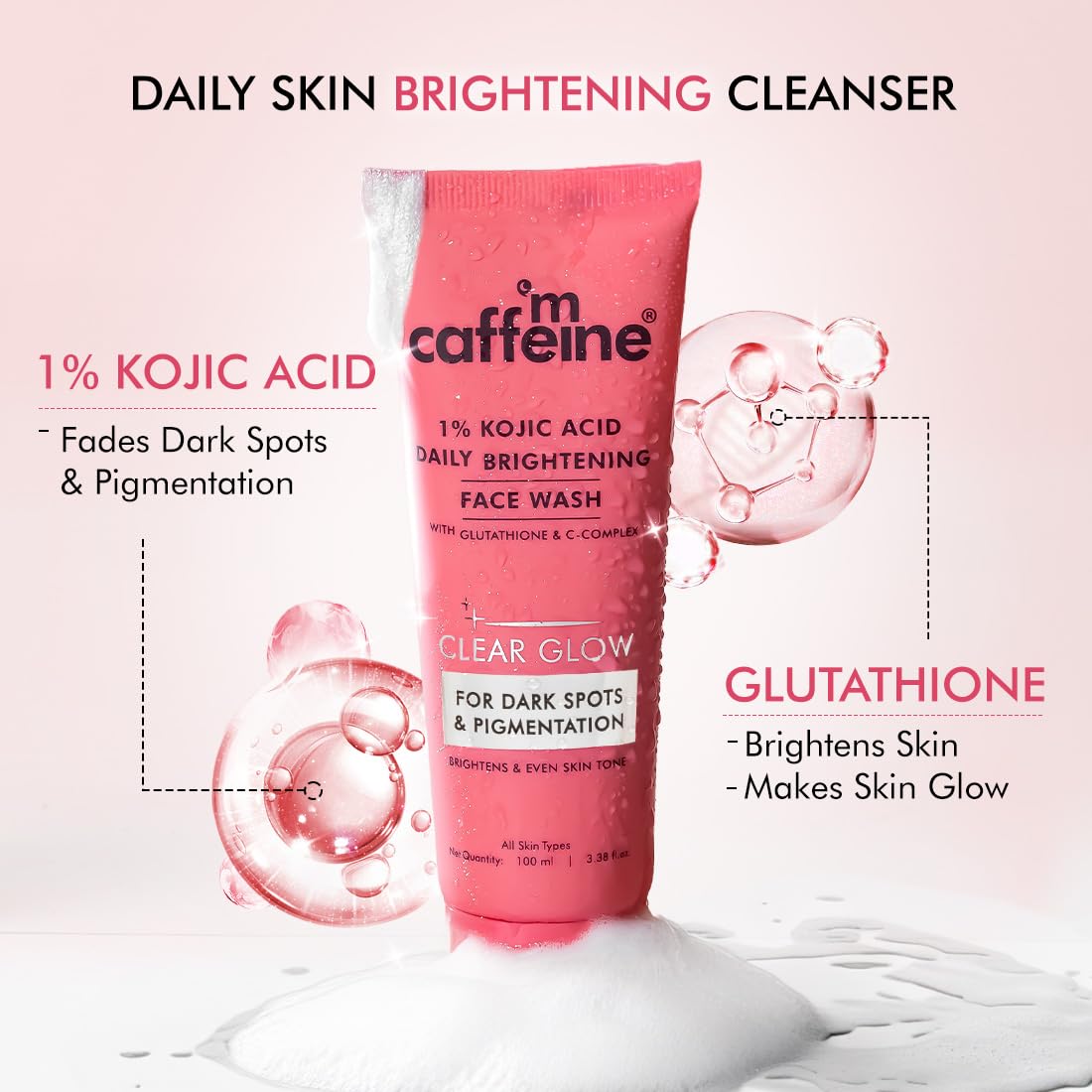 Pink tube of 'm caffeine' daily skin brightening cleanser with text highlighting ingredients on a pink background.