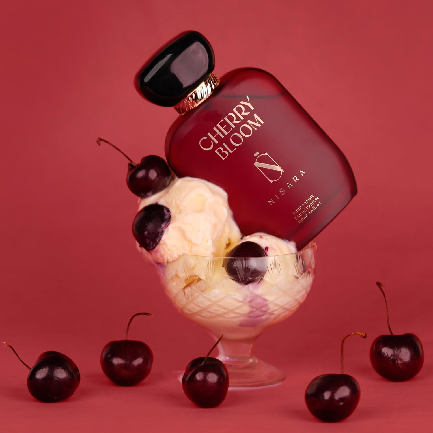 Perfume bottle labeled 'Cherry Bloom' with ice cream and cherries on a red background