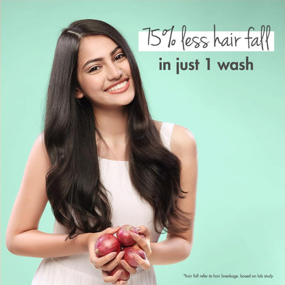 Woman with long, healthy hair holding apples against a light green background with text about hair fall reduction.