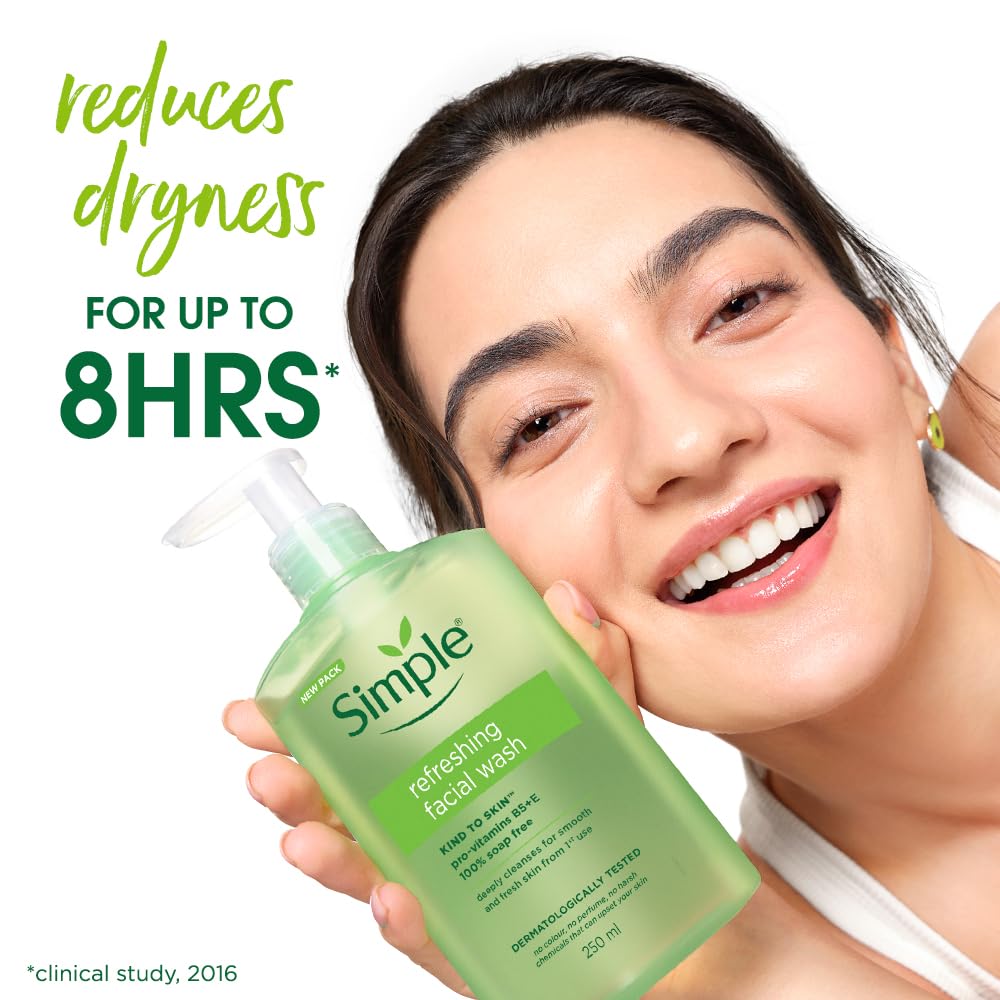 Woman holding a bottle of Simple refreshing facial wash with text indicating dryness reduction.