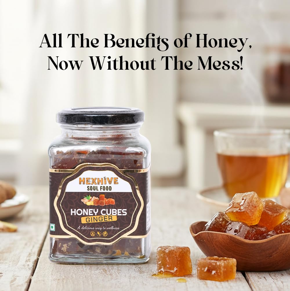 Jar of Hexhive Soul Food Honey Cubes Ginger on a wooden surface with tea and honey cubes.