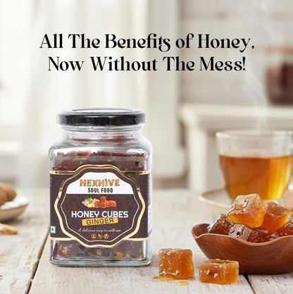 Jar of Hexhive Soul Food Honey Cubes Ginger on a wooden surface with tea and honey cubes.