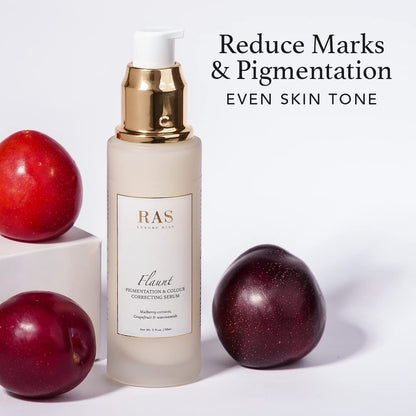 Skincare serum bottle with plums on a white background, labeled 'Reduce Marks & Pigmentation, Even Skin Tone'.