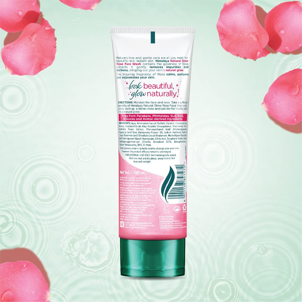 Tube of skincare product with pink label on a light green background with pink rose petals.