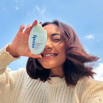 Person holding a 'moodly' product against a blue sky