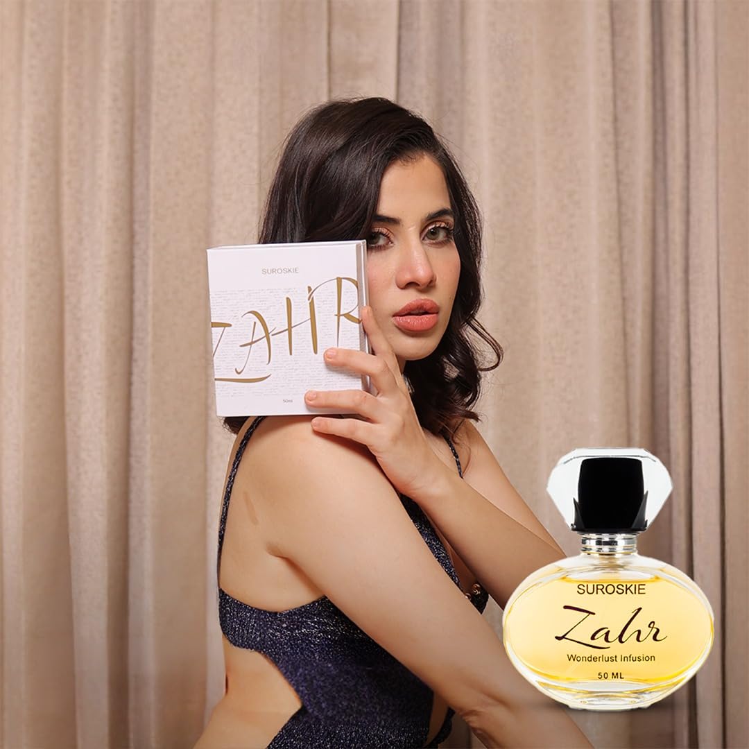 Woman holding a Suroskie Zahr perfume bottle and packaging against a beige curtain background