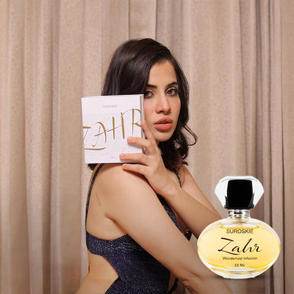 Woman holding a Suroskie Zahr perfume bottle and packaging against a beige curtain background