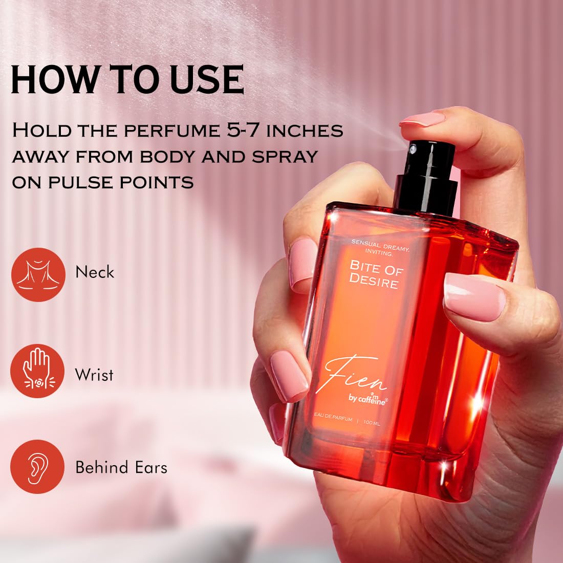 Hand holding a red perfume bottle with usage instructions on a pink background