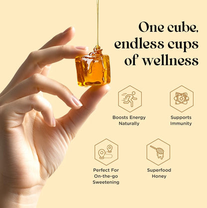 Hand holding a cube of honey with wellness benefits on a beige background