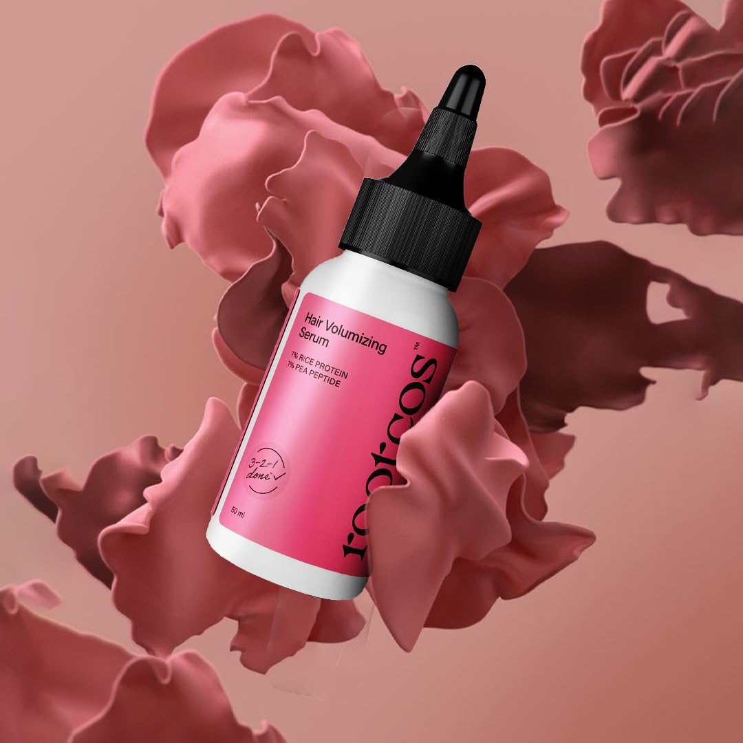 Hair volumizing serum bottle with pink label on a decorative pink background