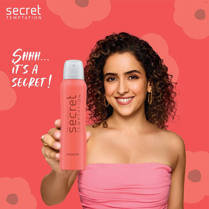 Woman holding a pink 'secret TEMPTATION' product against a red background with floral patterns.