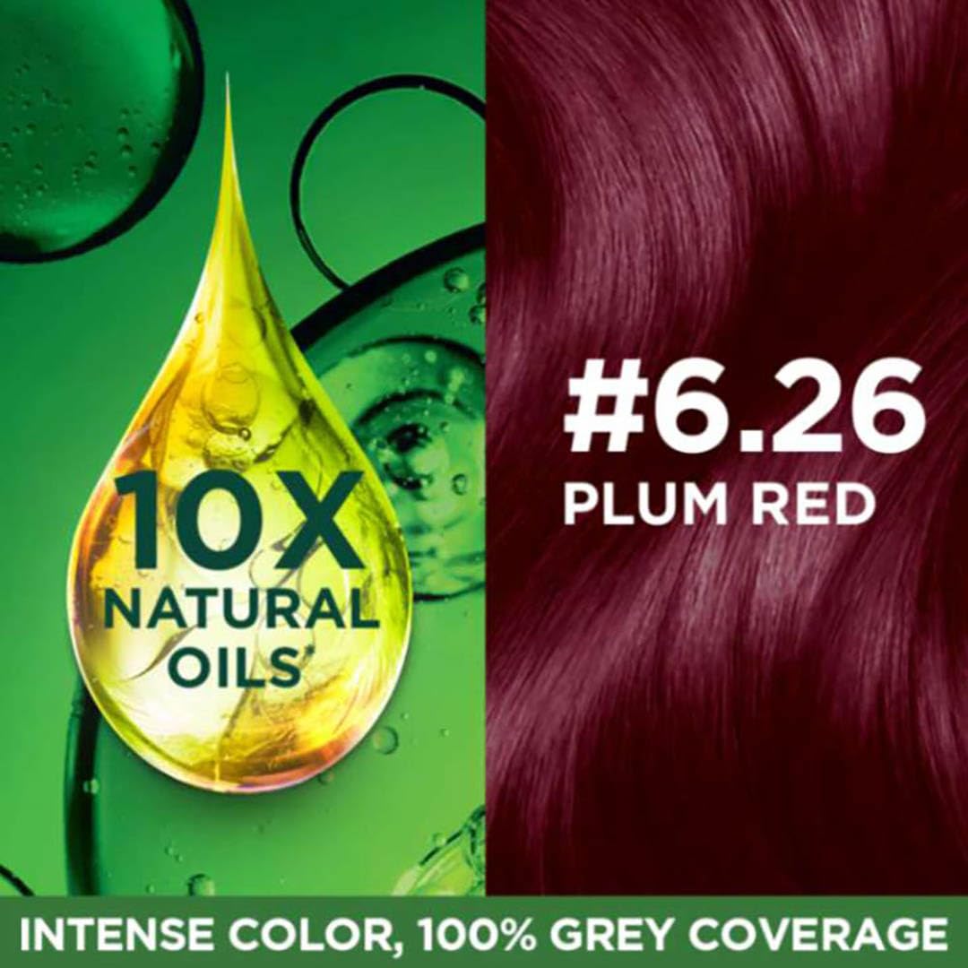 Hair color product with a droplet of oil and plum red hair color swatch on a green background.