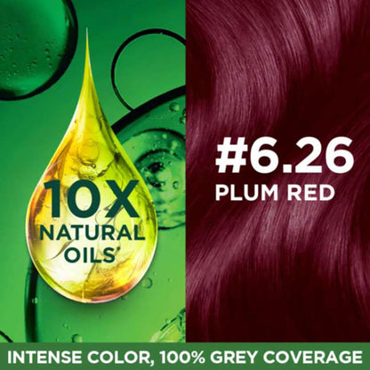Hair color product with a droplet of oil and plum red hair color swatch on a green background.