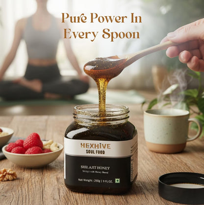Hexhive shilajit honey jar with a spoonful of honey being poured over it, on a wooden table with a blurred background.