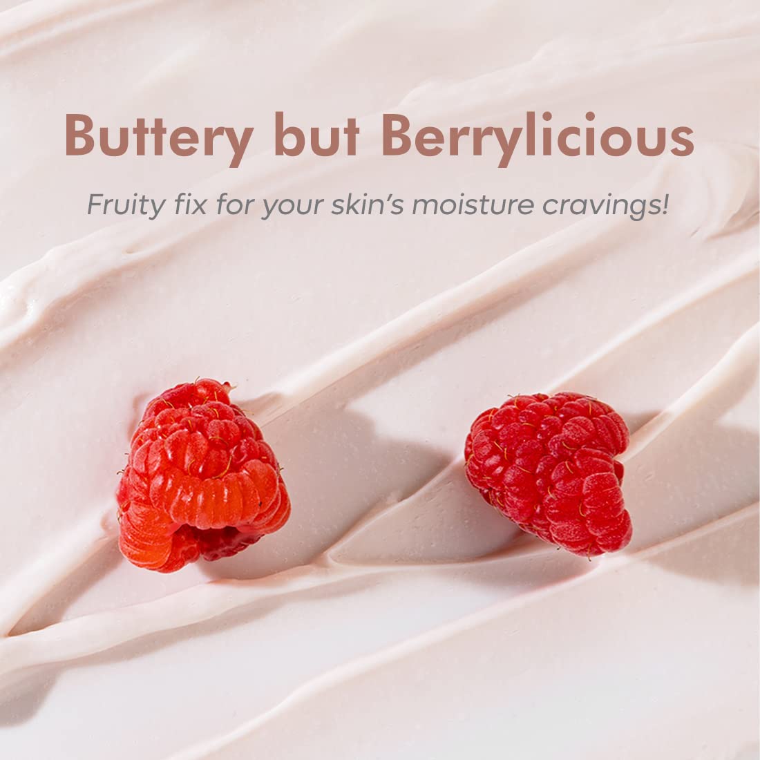 Two raspberries on a creamy background with text 'Buttery but Berrylicious' and 'Fruity fix for your skin's moisture cravings!'.