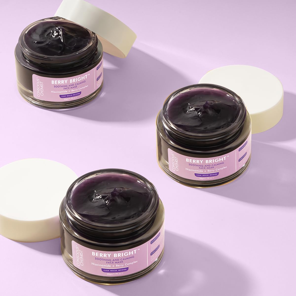 Three jars of 'Berry Bright' cream on a light purple background