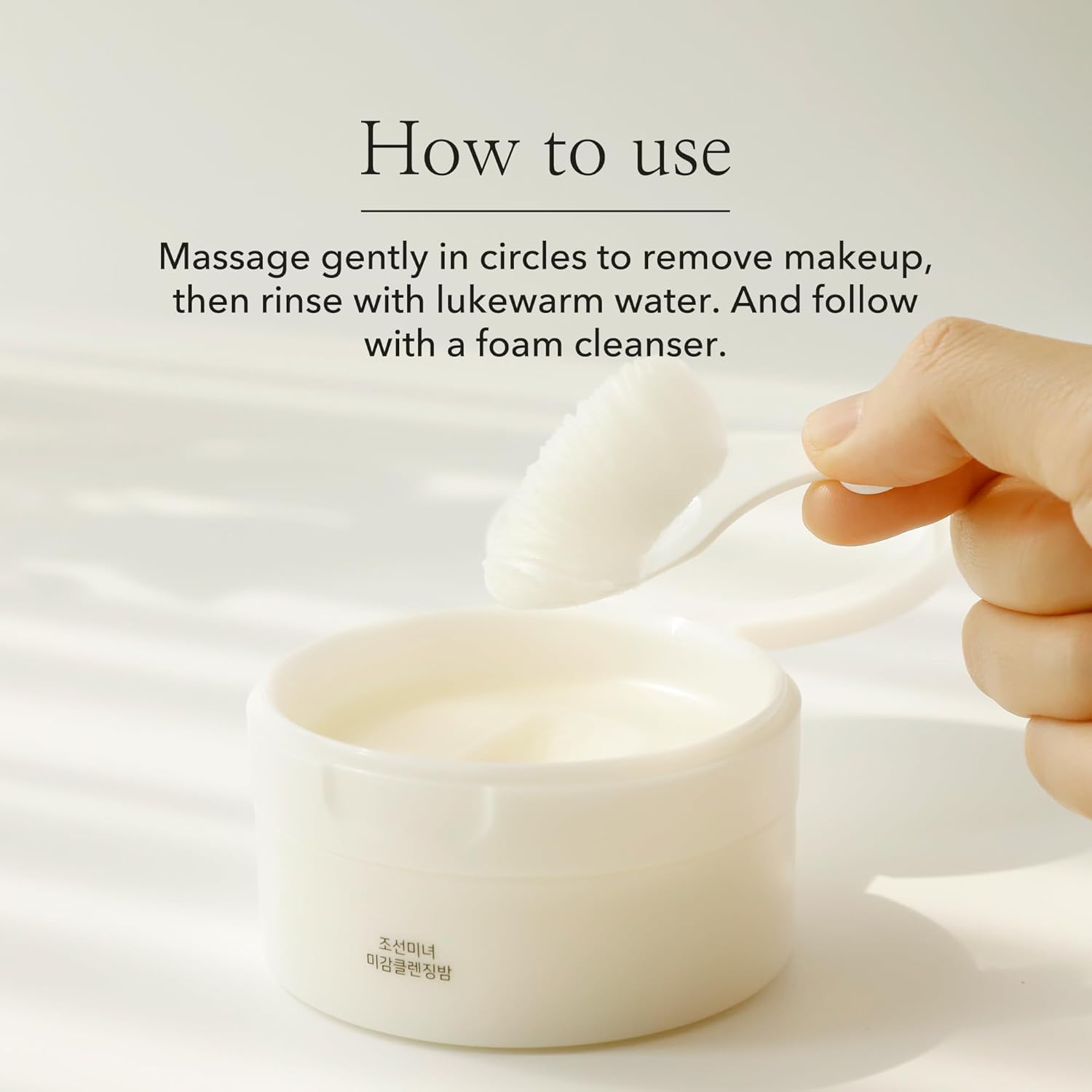 Hand using a white spoon to scoop cream from a jar with text on how to use it.