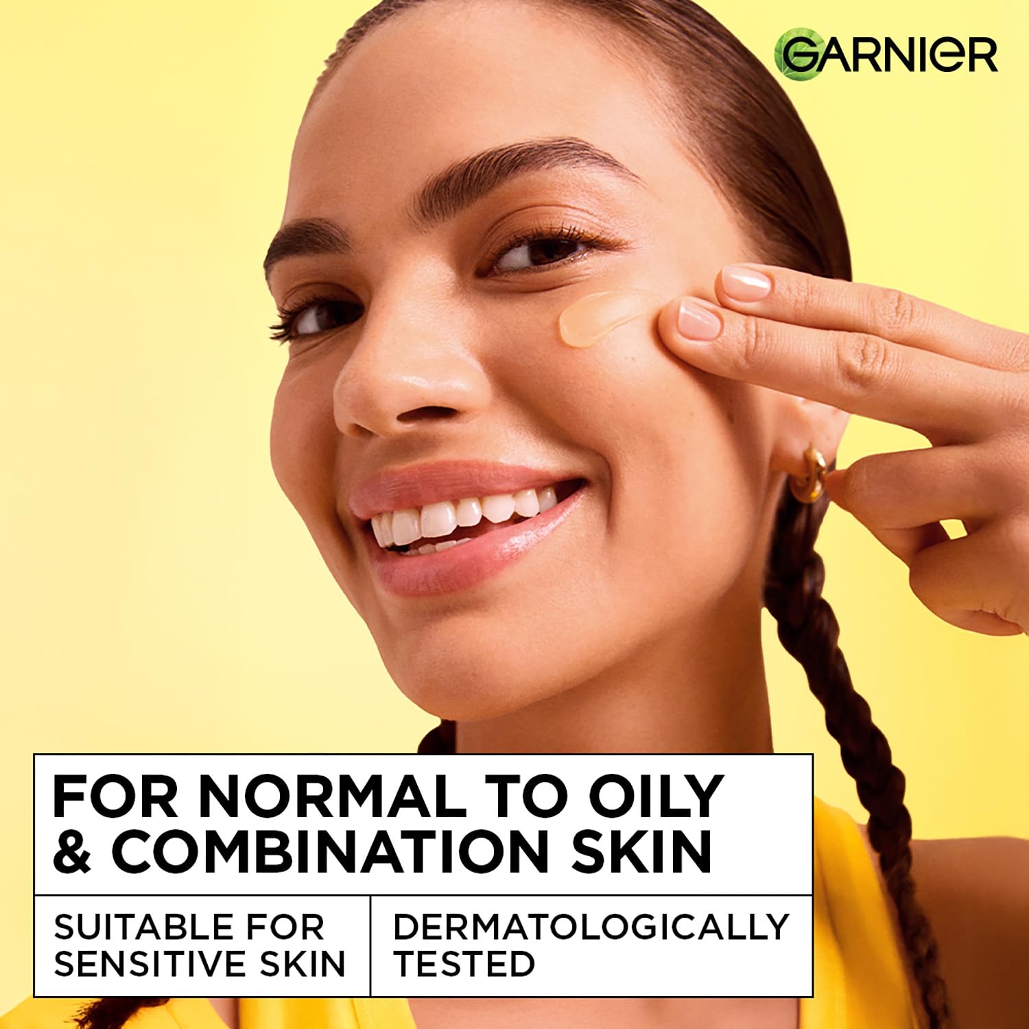 Woman applying skincare product on her face with Garnier logo and product information text.