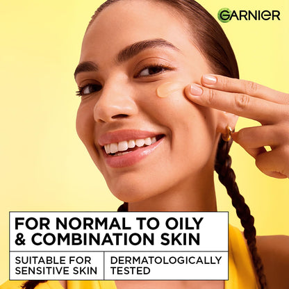 Woman applying skincare product on her face with Garnier logo and product information text.