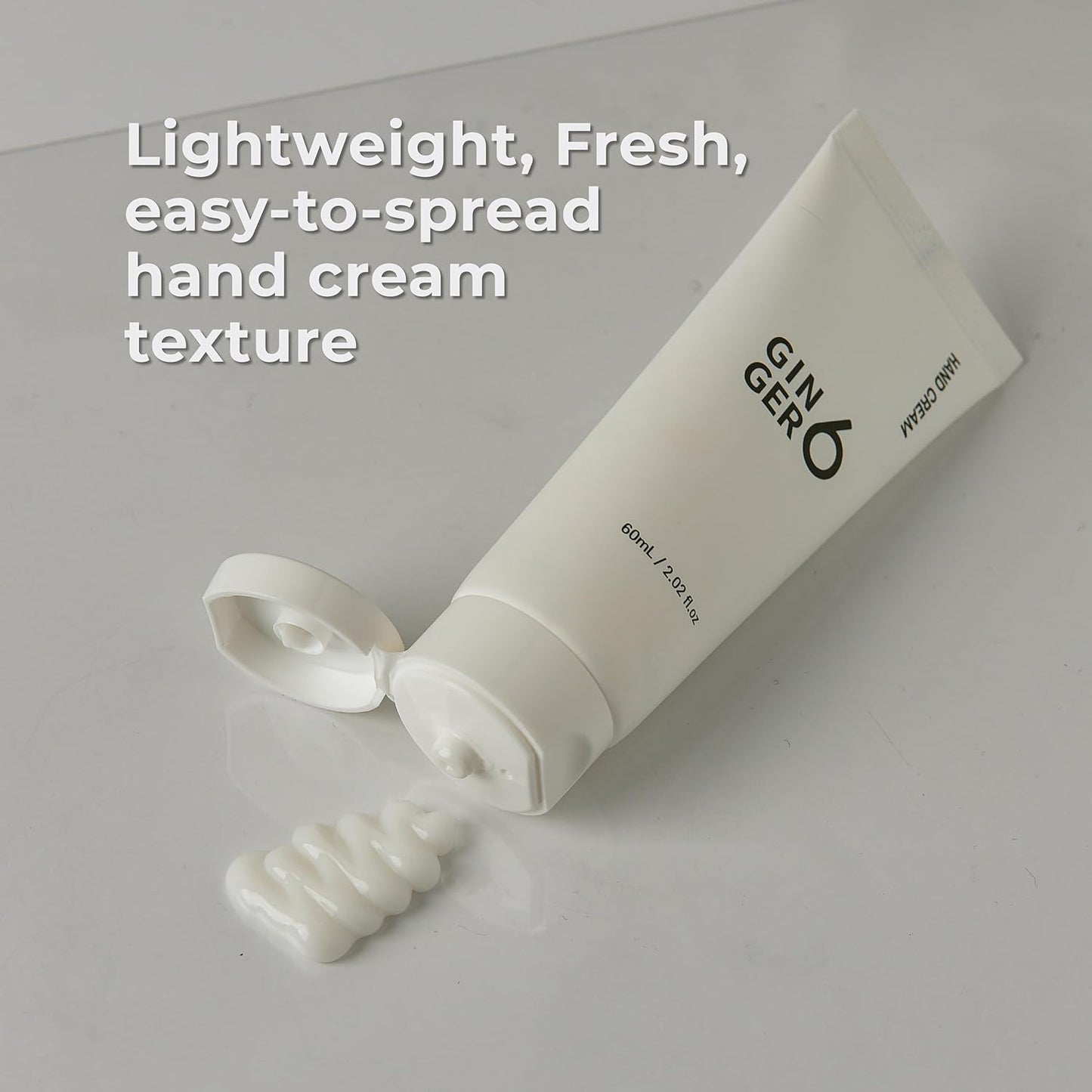 White hand cream tube with text on a light gray background