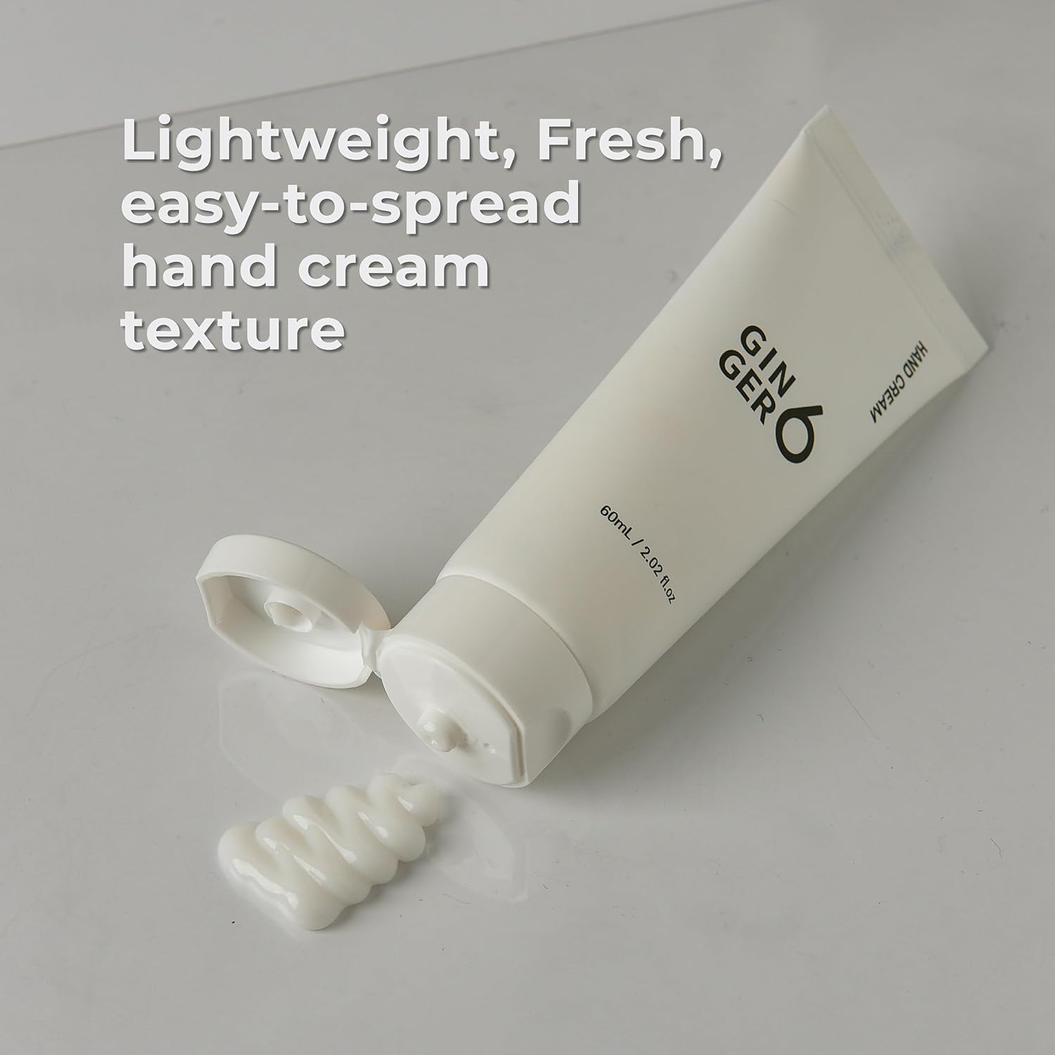 White hand cream tube with text on a light gray background