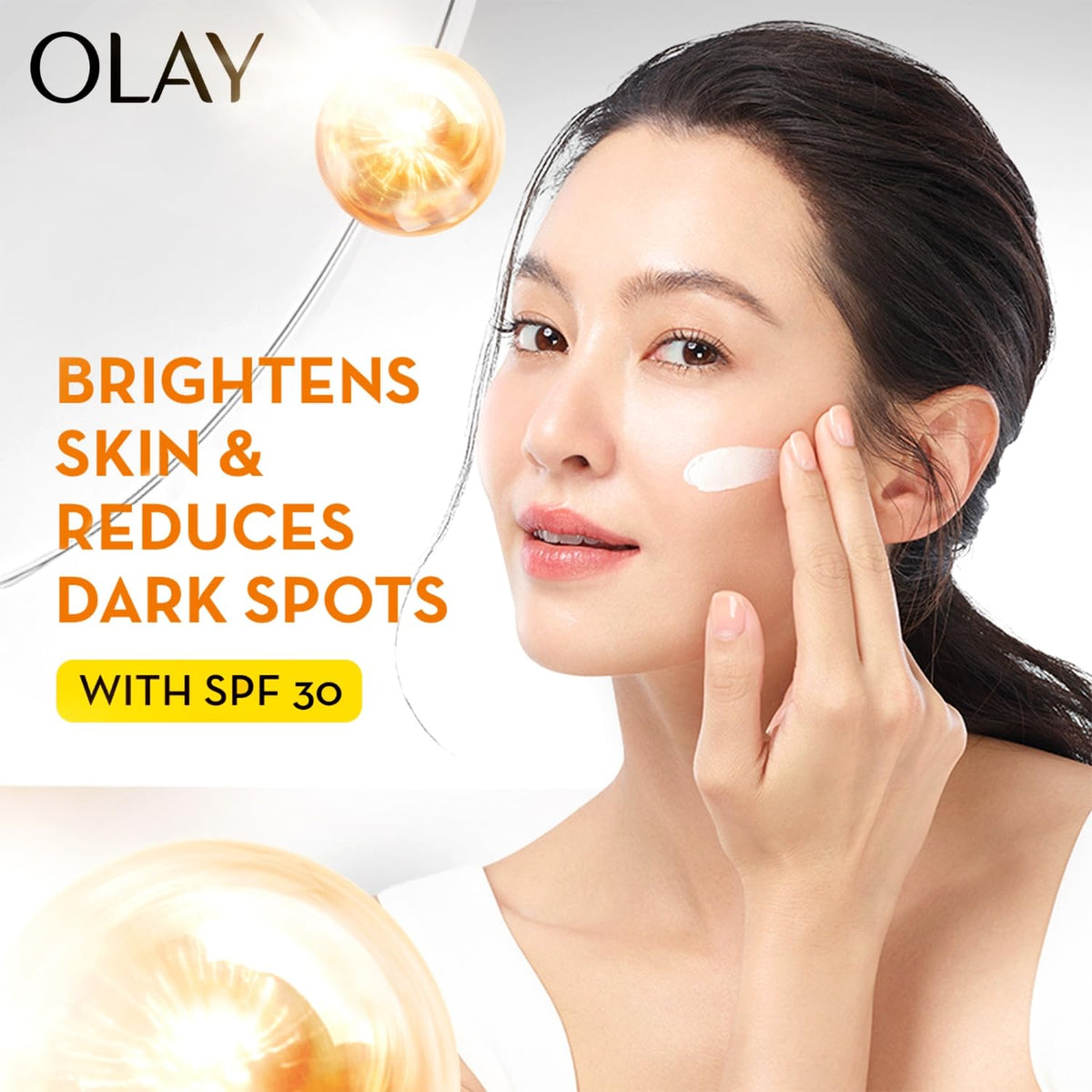 OLAY skincare product advertisement with a woman applying cream and text highlighting benefits.