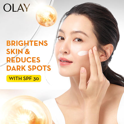 OLAY skincare product advertisement with a woman applying cream and text highlighting benefits.