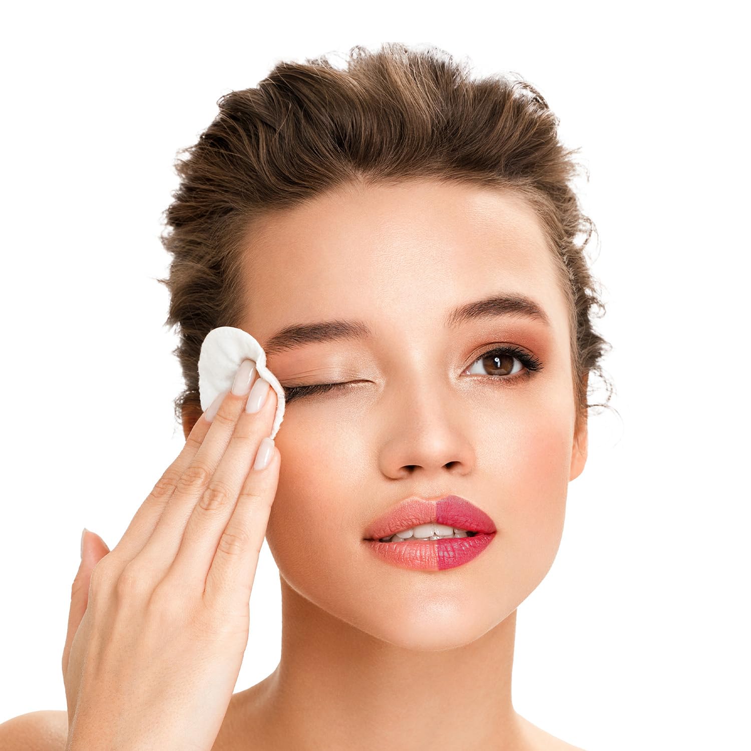 Woman applying a white cotton pad to her face against a white background