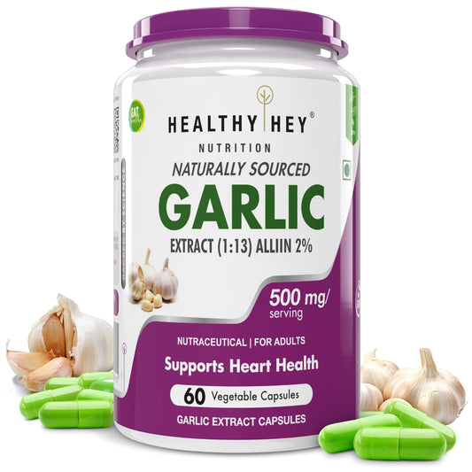 Garlic supplement container with garlic bulbs and capsules on a white background