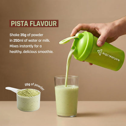 Green protein shake being poured into a glass with text about pista flavor and protein content.