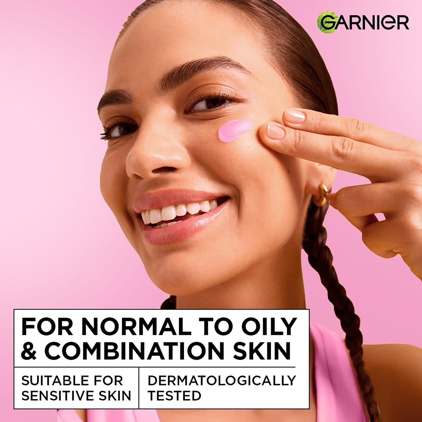 Woman applying skincare product on her face with Garnier logo and product information text.