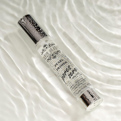 Pearl primer bottle with decorative text on a white fabric background