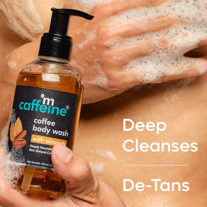 Caffeine coffee body wash bottle with a hand holding it and another hand applying soap, text 'Deep Cleanses De-Tans' on a blurred background.