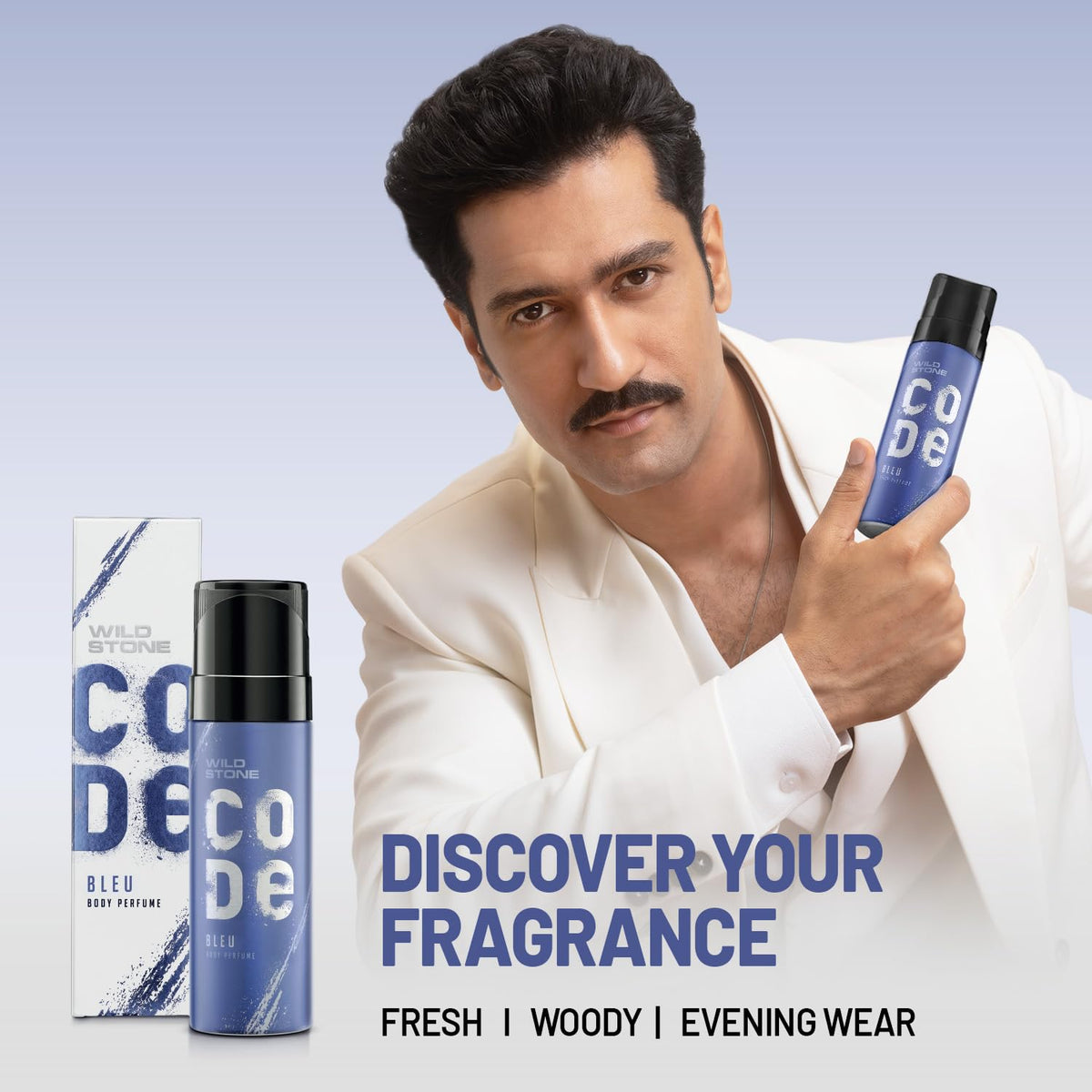Man holding a Wild Stone Code perfume bottle with packaging on a light blue background