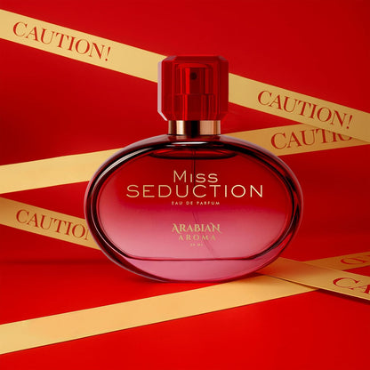 Red 'Miss Seduction' perfume bottle with gold ribbons on a red background