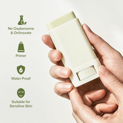 Hand holding a white deodorant stick with green icons and text on a light background