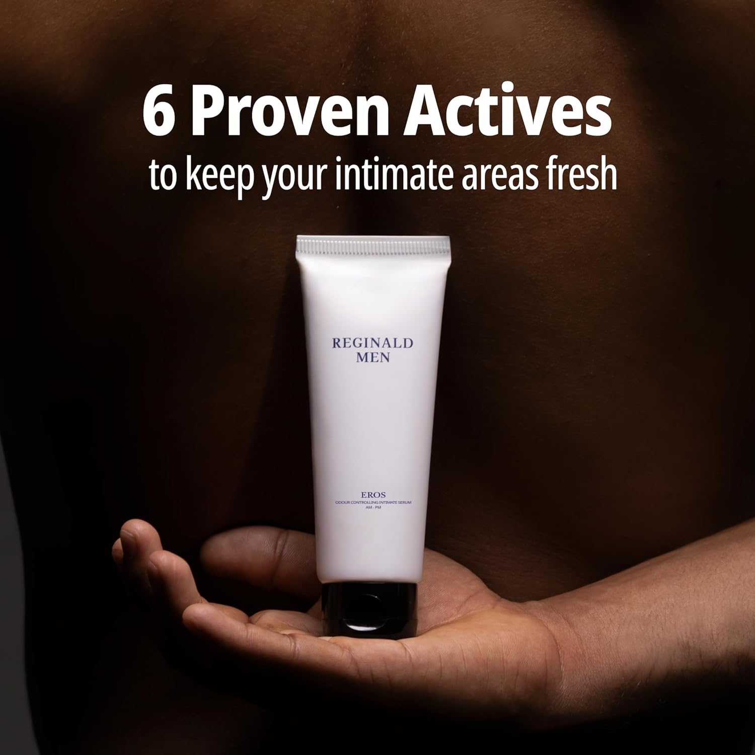 Hand holding a tube of 'Reginald Men' product with text about proven actives on a dark background